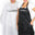white hair cape and a black apron with black and white text printed on it respectively. It says Peter Coppola Keratin Concept.